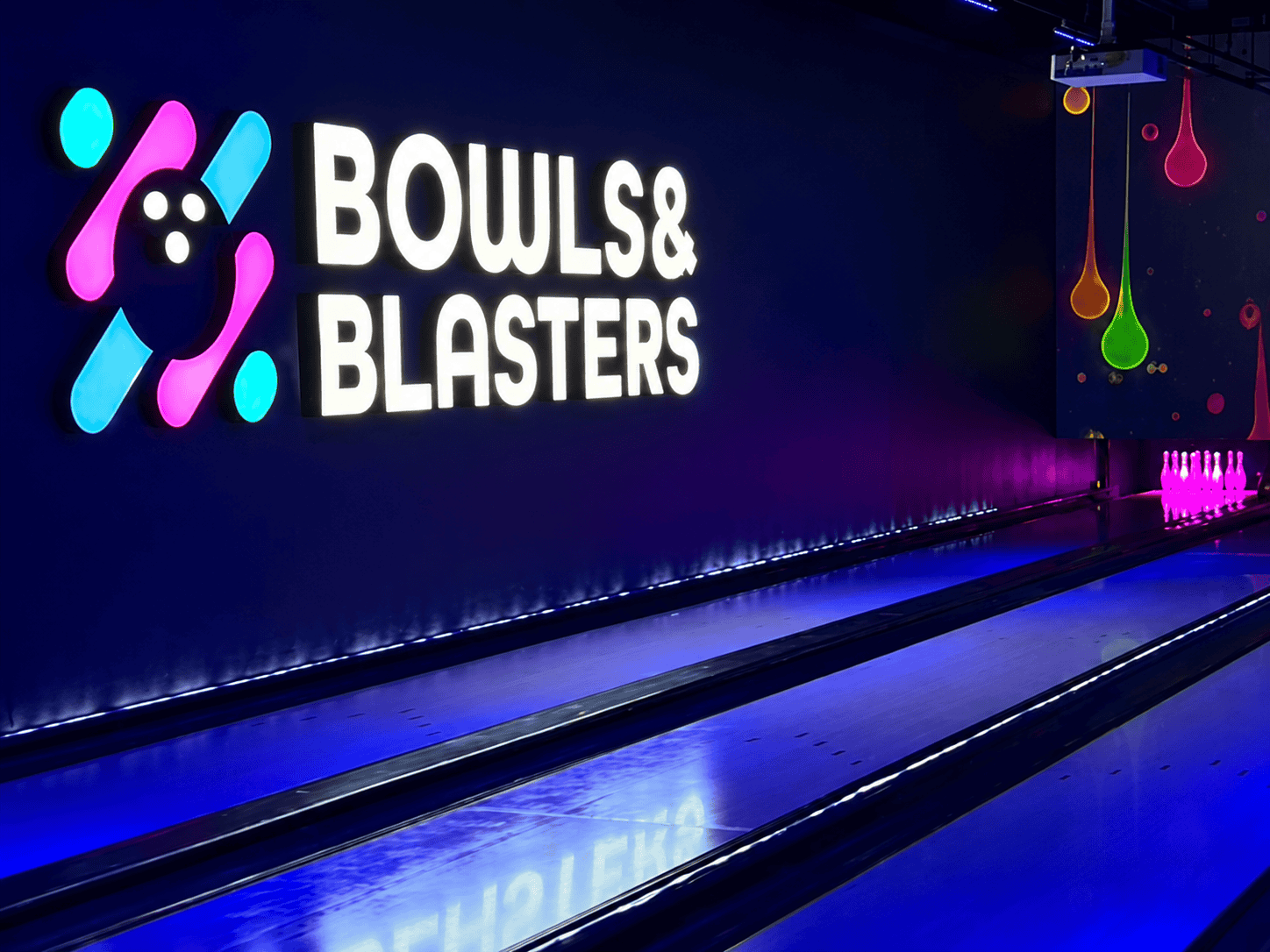 Social gaming at Bowls & Blasters featuring Funk duckpin bowling lanes with colorful lighting and interactive projection.